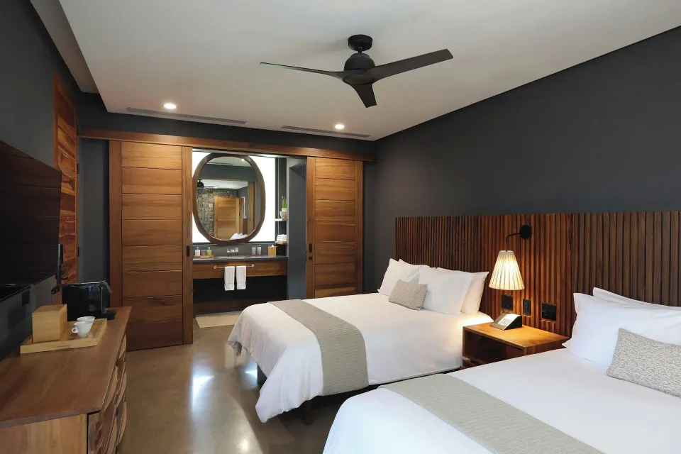 Bedroom with two double beds and vanity in a Balcony Garden View Three-Bedroom Villa at El Mangroove Papagayo