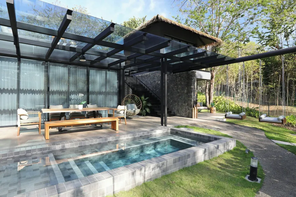 Pool and shaded terrace with dining table outside Balcony Garden View Three-Bedroom Villa at El Mangroove Papagayo