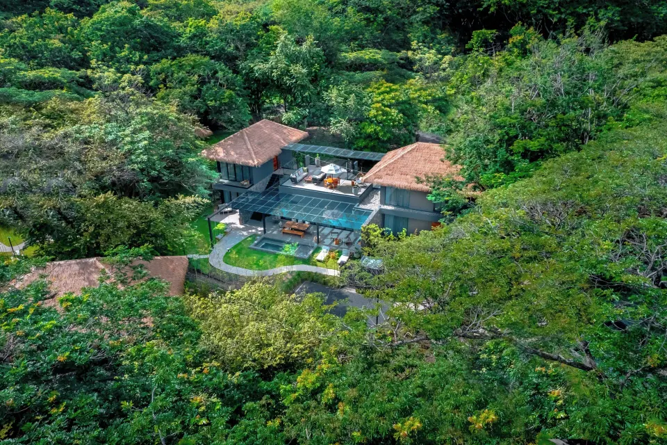 Aerial view of a three-bedroom villa set within lush tropical trees at El Mangroove Papagayo