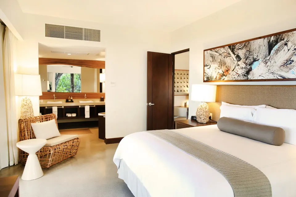Presidential Suite king bed with open view into the bathroom at El Mangroove Papagayo