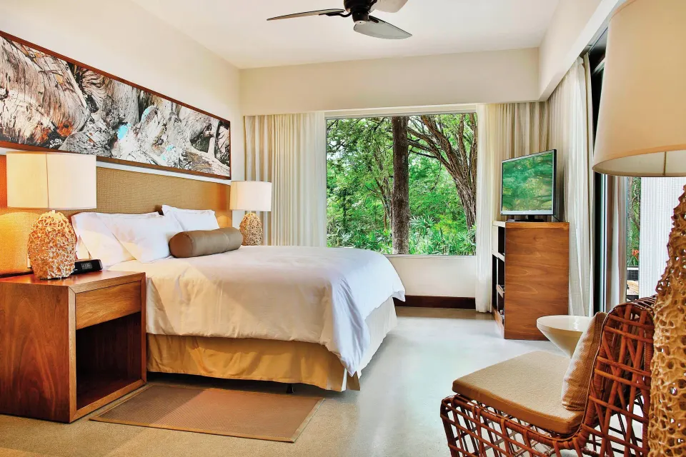 Bedroom with king bed and garden-view window in a Presidential Suite at El Mangroove Papagayo