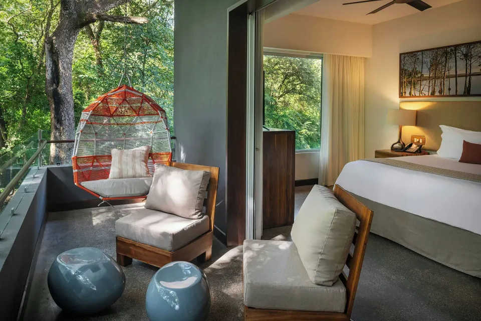 Balcony seating and bedroom view in a Superior Balcony One-Bedroom Suite at El Mangroove Papagayo
