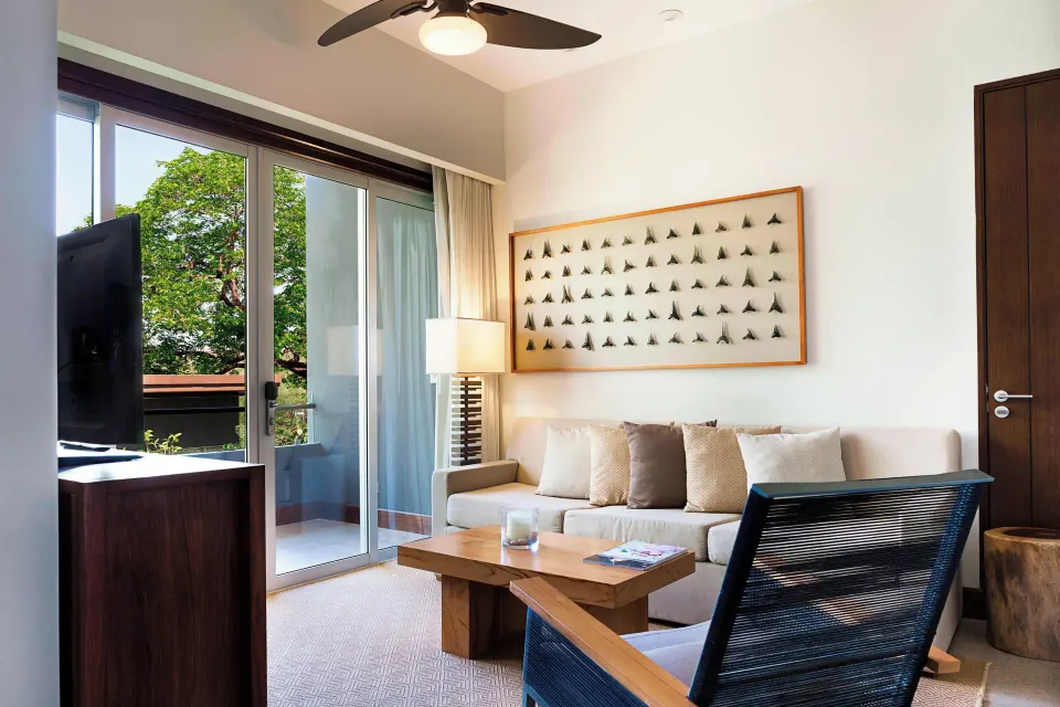 Living area with sofa bed and balcony view in a Resort View Junior Suite at El Mangroove Papagayo
