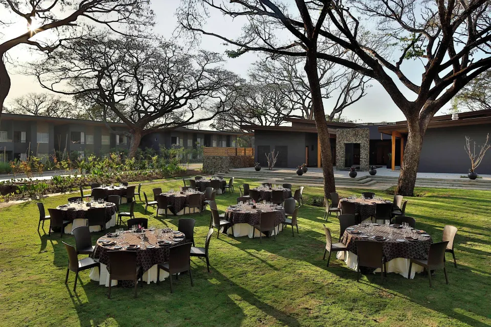 Outdoor lawn banquet setup with round tables at El Mangroove Papagayo