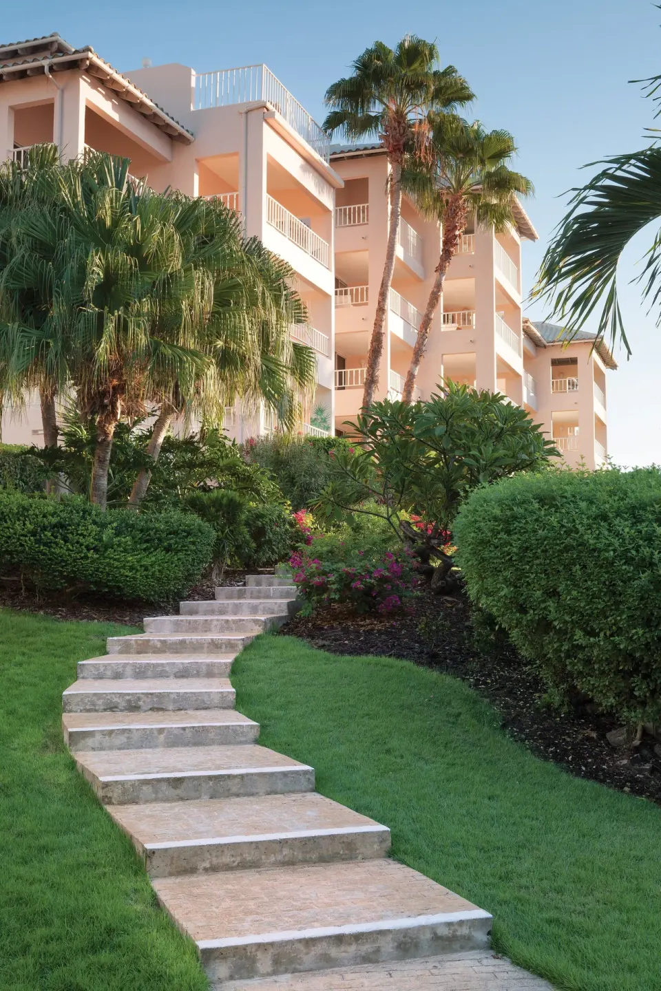 Garden steps leading toward balcony buildings at Elysian Beach Resort.