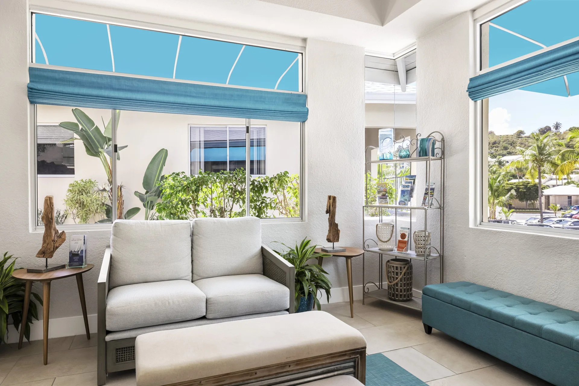 Bright lobby seating area with blue accents and large windows at Elysian Beach Resort.