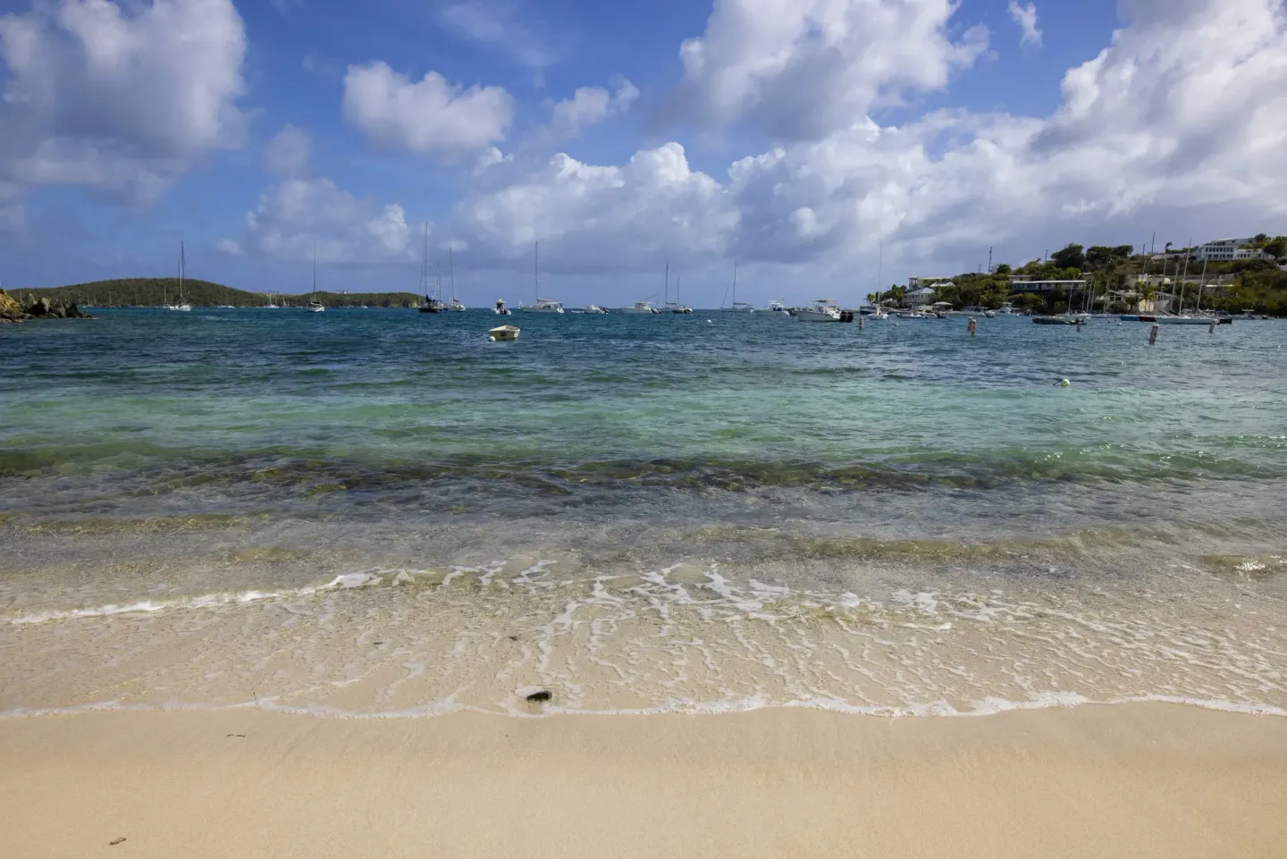 Clear shoreline water and anchored boats off the beach at Elysian Beach Resort.