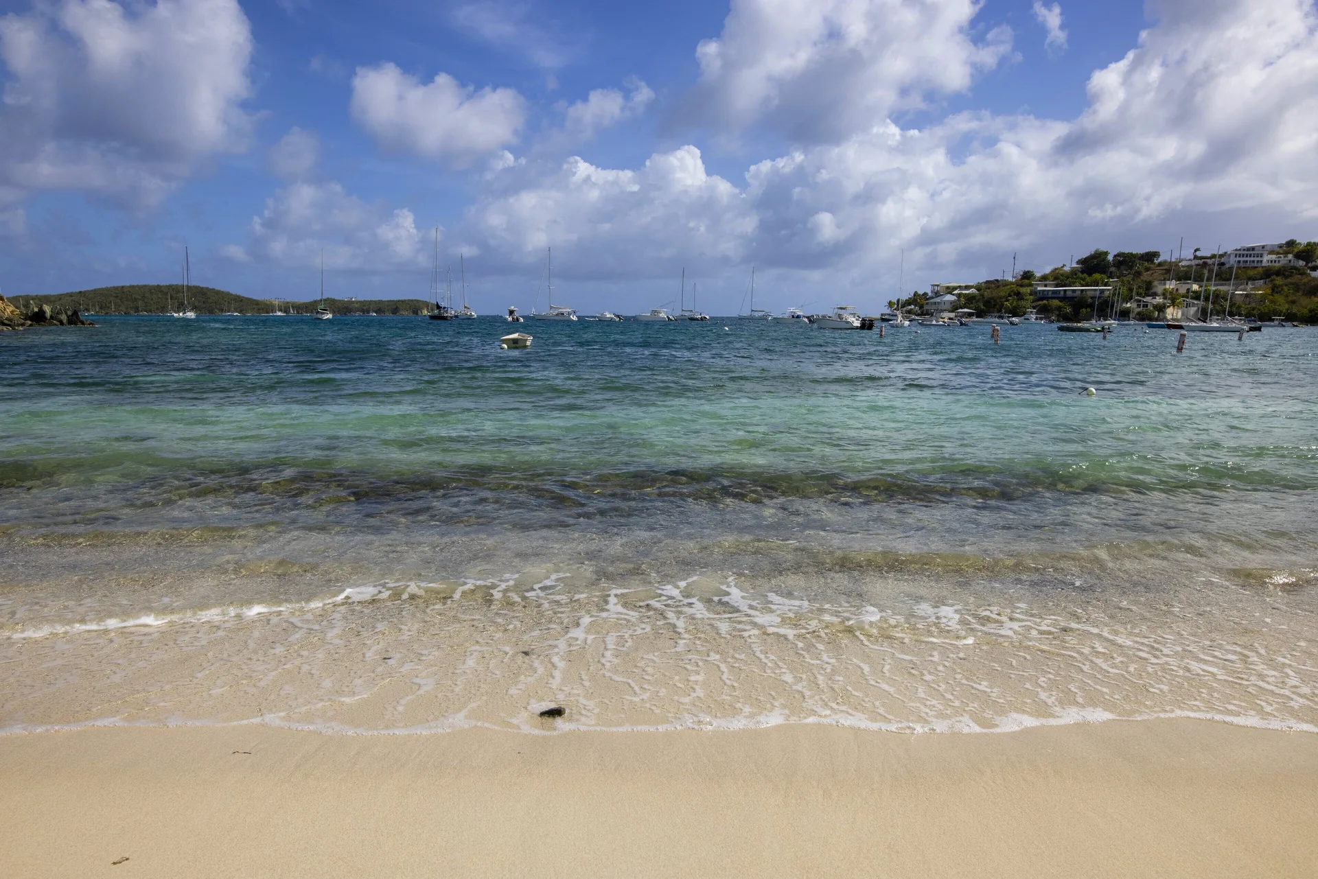 Clear shoreline water and anchored boats off the beach at Elysian Beach Resort.