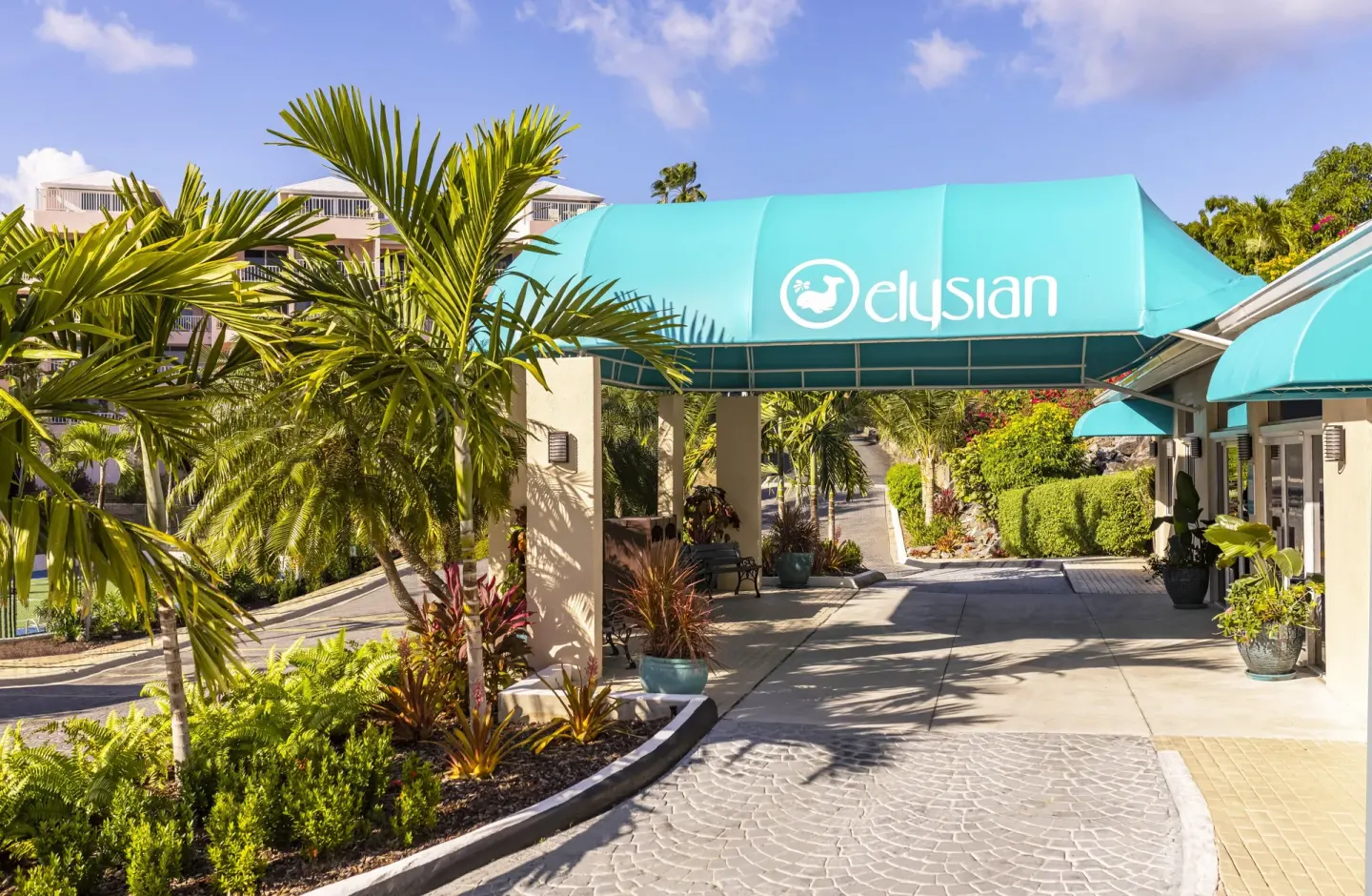 Tropical entrance walkway with a turquoise canopy at Elysian Beach Resort.