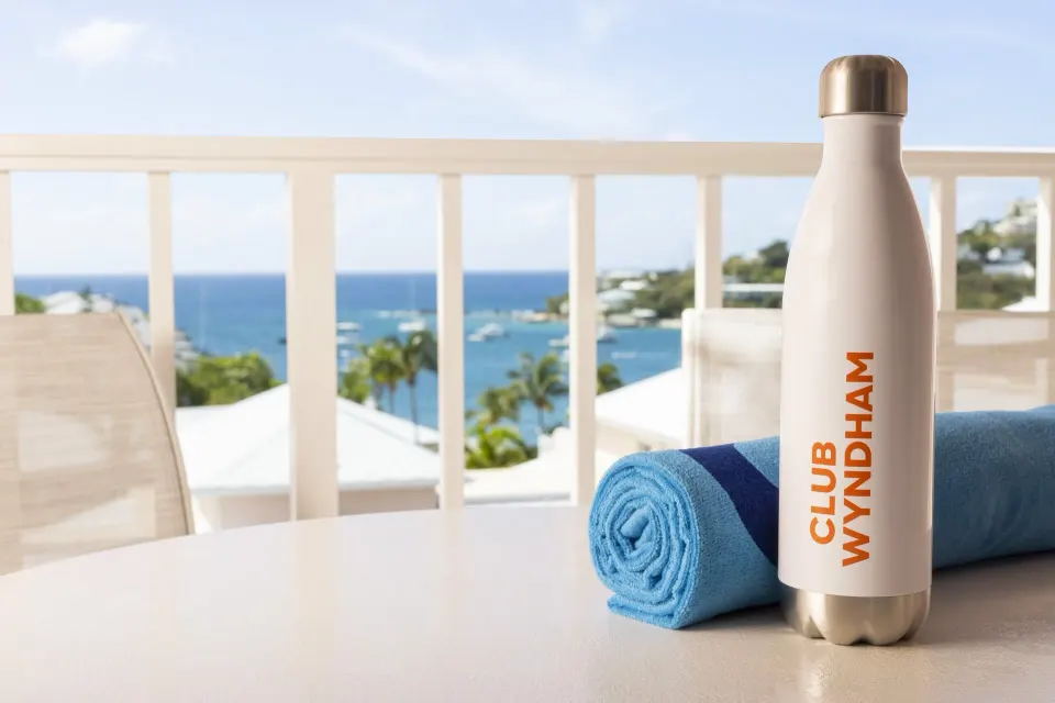 Standard Studio balcony with towel and water bottle at Elysian Beach Resort.
