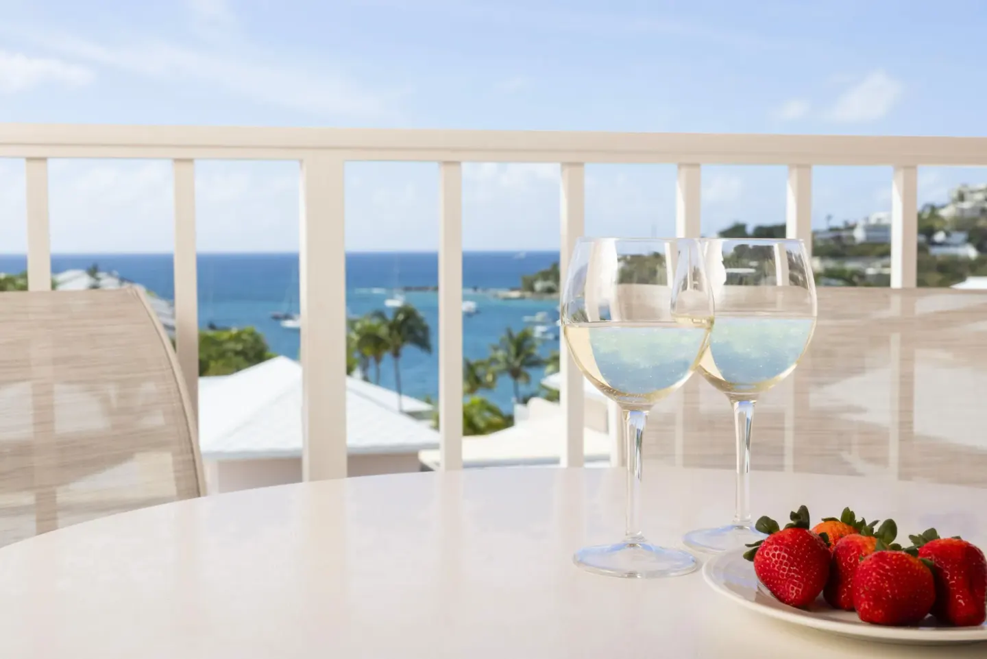 Standard Studio balcony table with drinks and harbor view at Elysian Beach Resort.