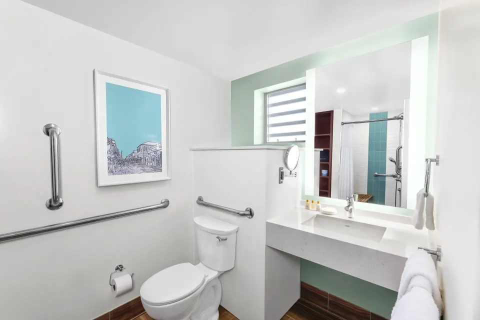 Standard Studio bathroom with vanity and accessible grab bars at Elysian Beach Resort.