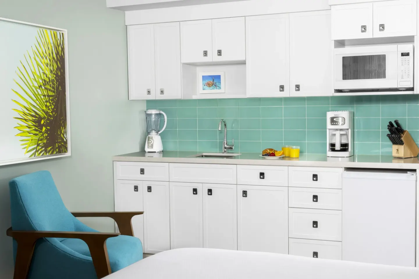 Standard Studio kitchenette with white cabinets at Elysian Beach Resort.