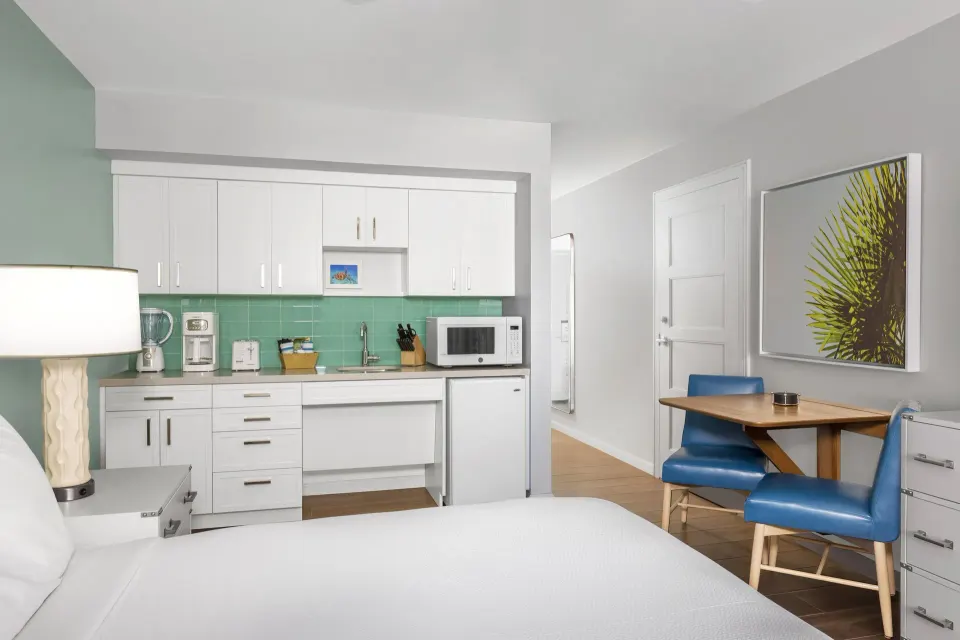 Standard Studio king bed with kitchenette and dining table at Elysian Beach Resort.