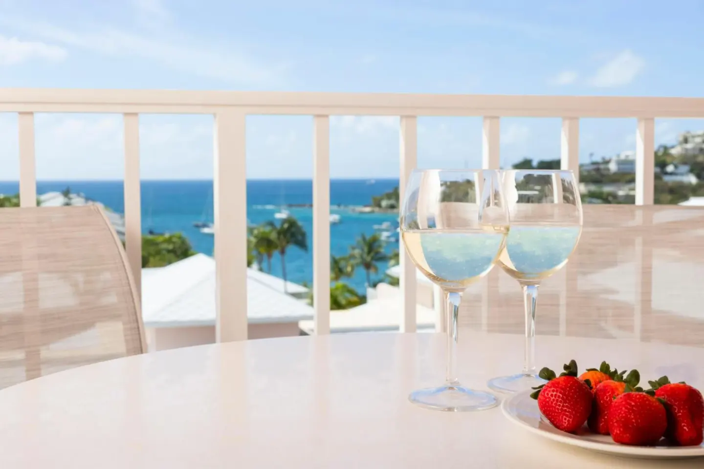 Studio parlor suite balcony table with wine glasses and berries at Elysian Beach Resort.