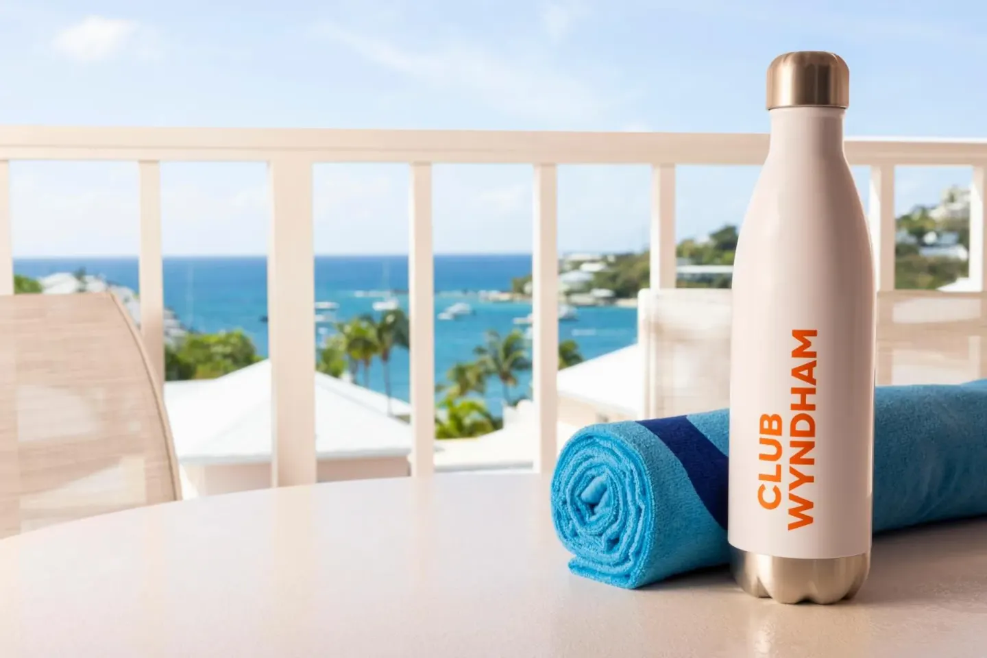 Studio parlor suite balcony table with towel and bottle at Elysian Beach Resort.