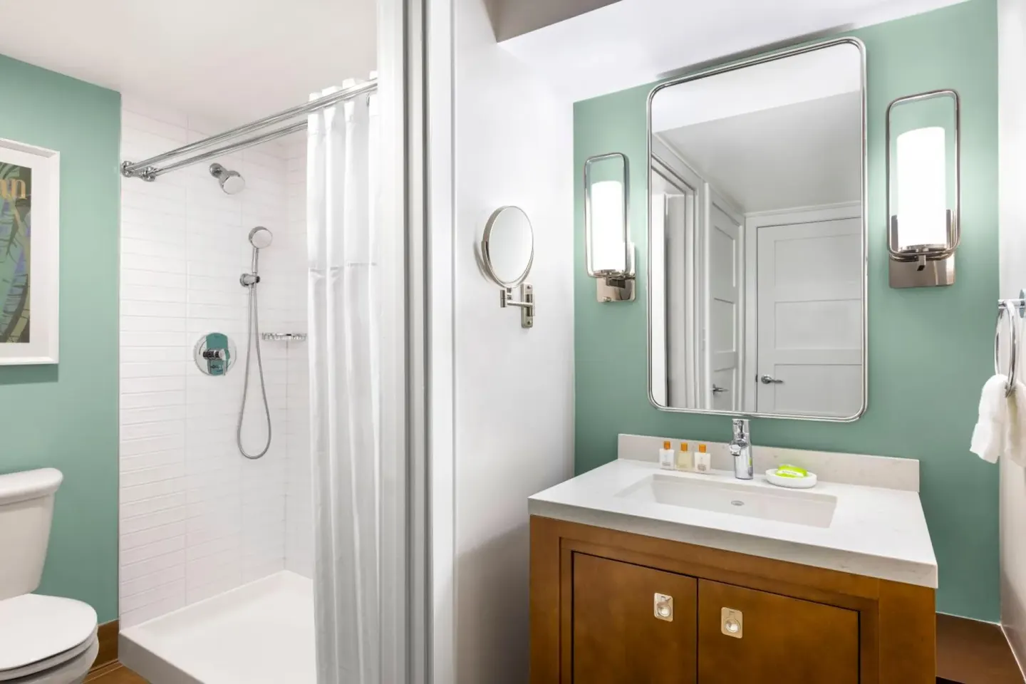 Studio parlor suite bathroom with vanity, mirror and walk-in shower at Elysian Beach Resort.