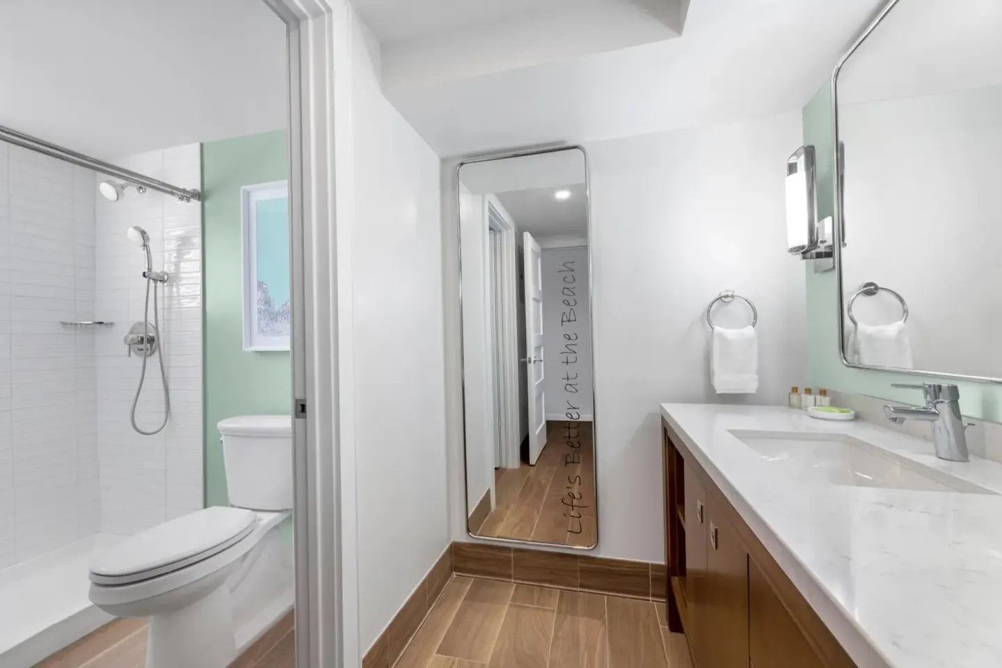 Studio parlor suite bathroom with shower, vanity and mirror at Elysian Beach Resort.
