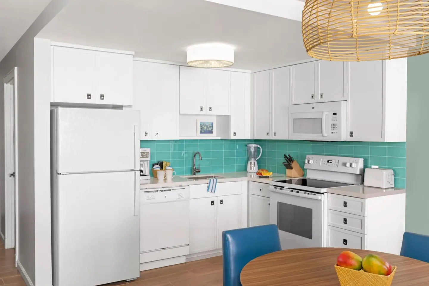 Studio Parlor Suite kitchen with white cabinets and turquoise tile at Elysian Beach Resort.