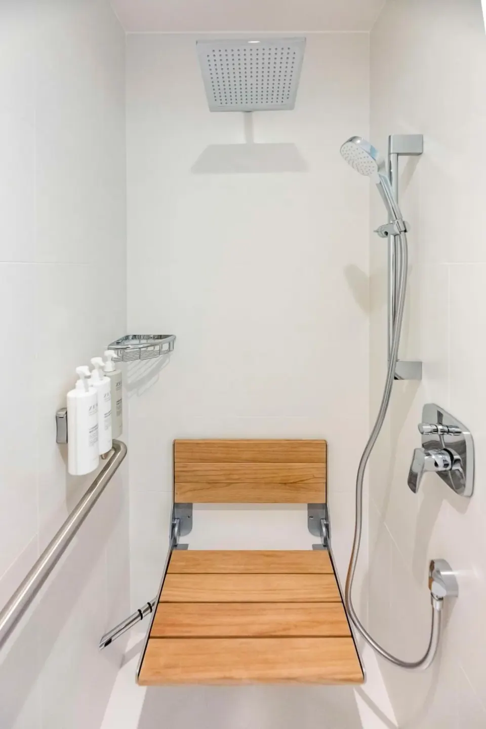 Accessible shower with bench and handheld sprayer at Embassy Suites Aruba Beach Resort.