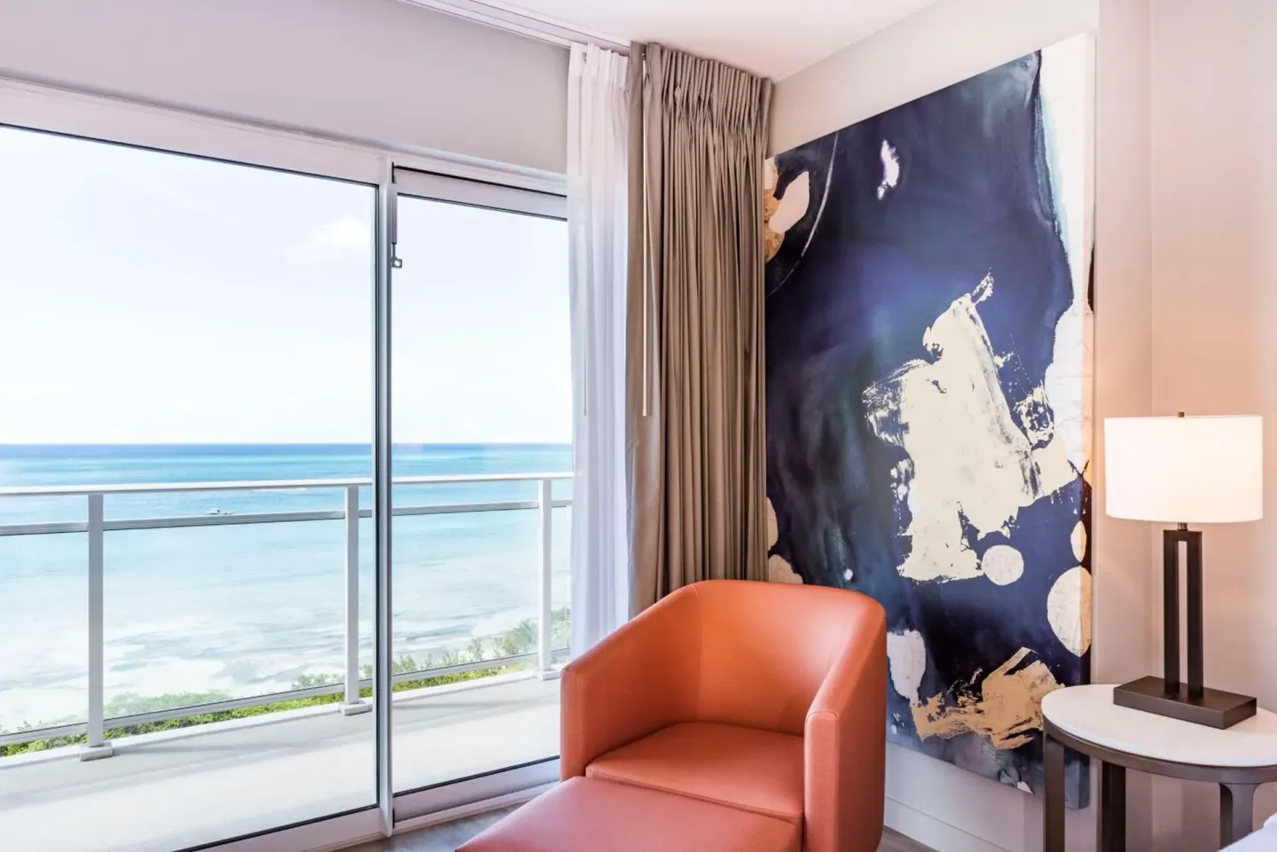 Guest room sitting corner with ocean view at Embassy Suites Aruba Beach Resort.