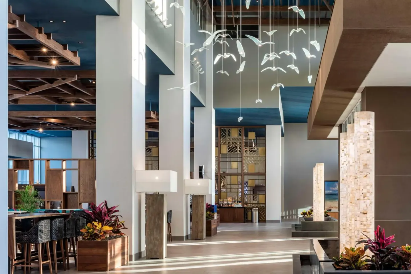 Lobby seating area with hanging bird sculpture at Embassy Suites Aruba Beach Resort.