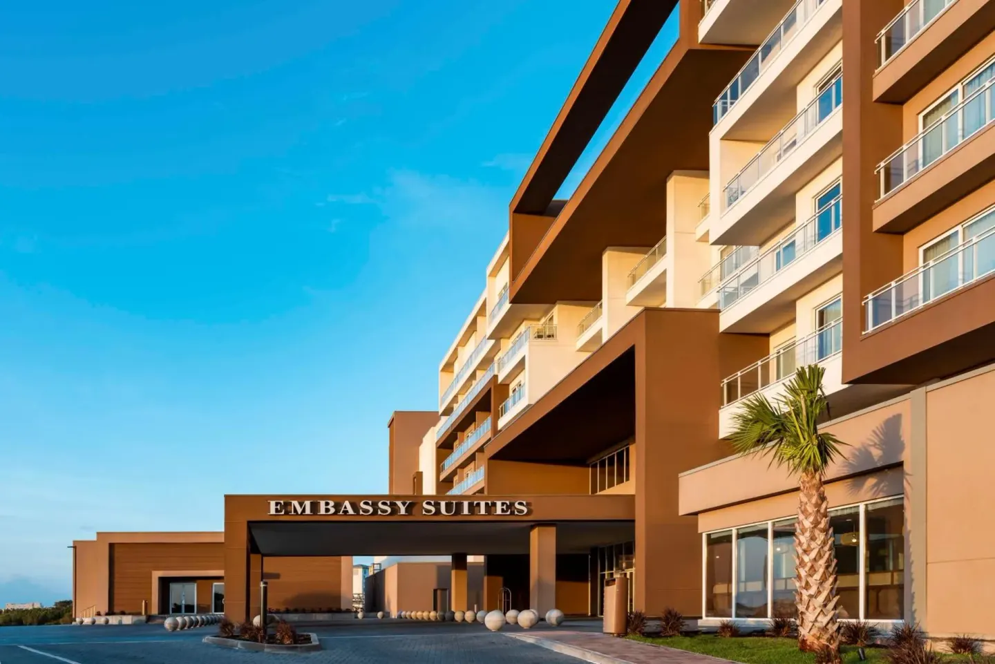 Exterior entrance canopy and guest balconies at Embassy Suites Aruba Beach Resort.