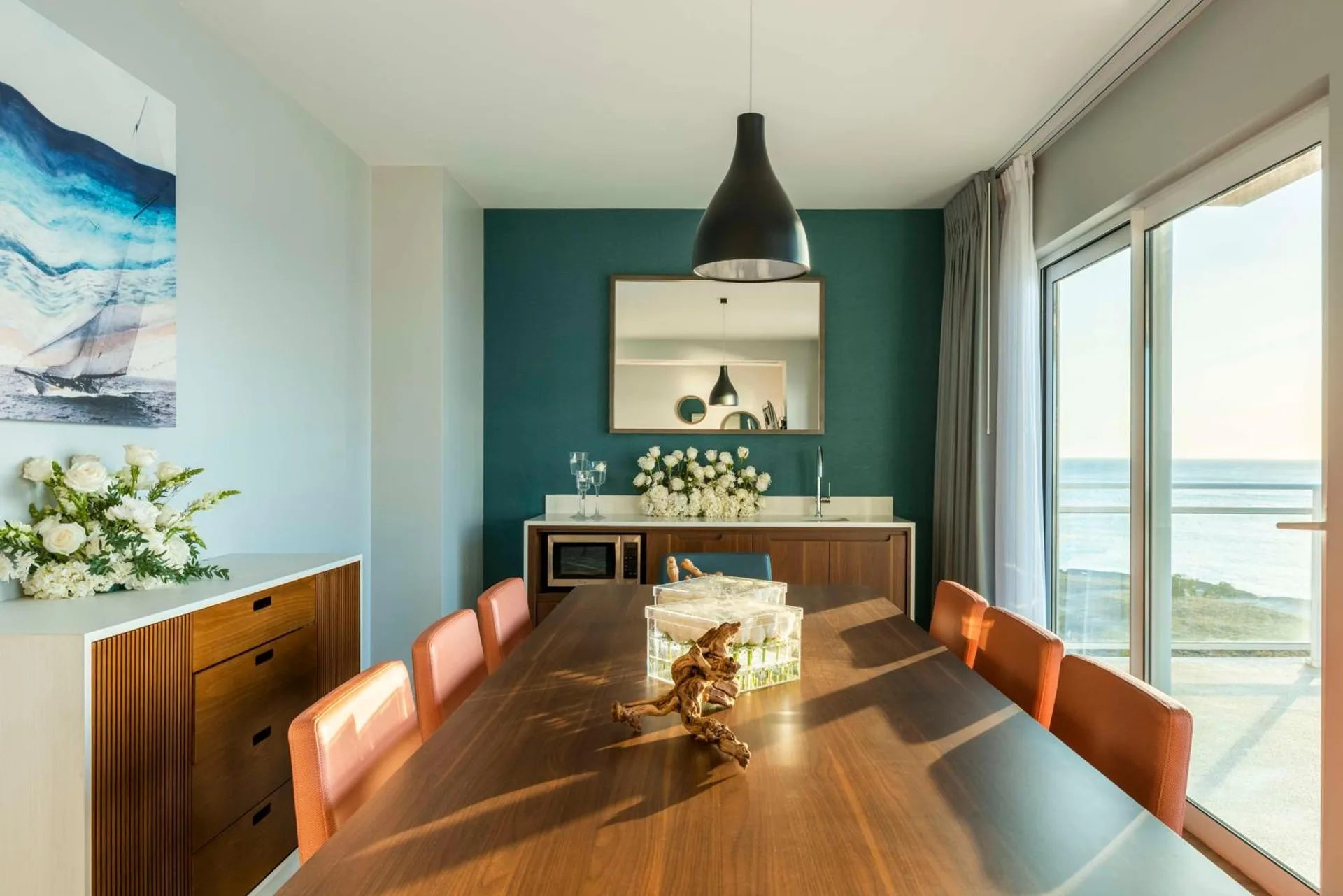 Dining table and ocean-facing windows in a suite at Embassy Suites Aruba Beach Resort.
