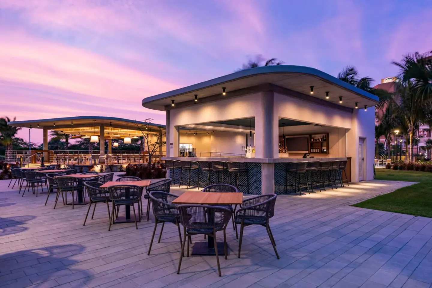 Open-air pool bar with patio seating at Embassy Suites Aruba Beach Resort.