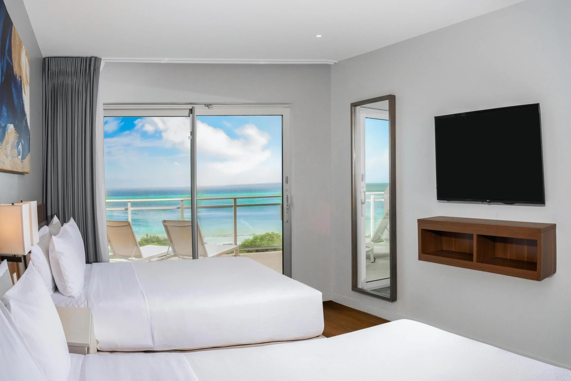 Two-bed ocean front balcony suite bedroom at Embassy Suites Aruba Beach Resort.
