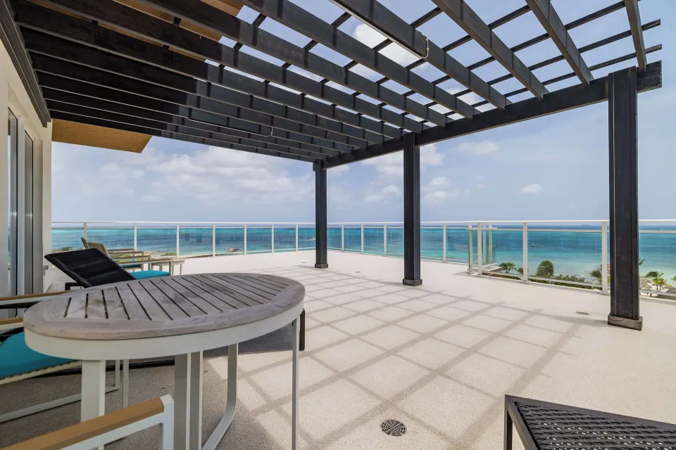 Suite Ocean Front Balcony terrace with loungers and ocean view at Embassy Suites Aruba Beach Resort.