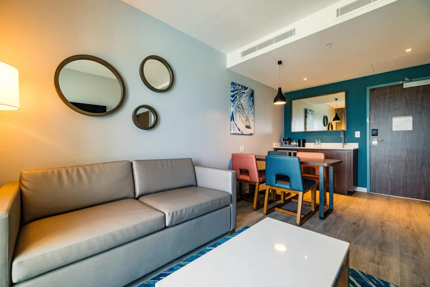 Ocean-view one-bedroom suite living area with sofa and dining table at Embassy Suites Aruba Beach Resort.