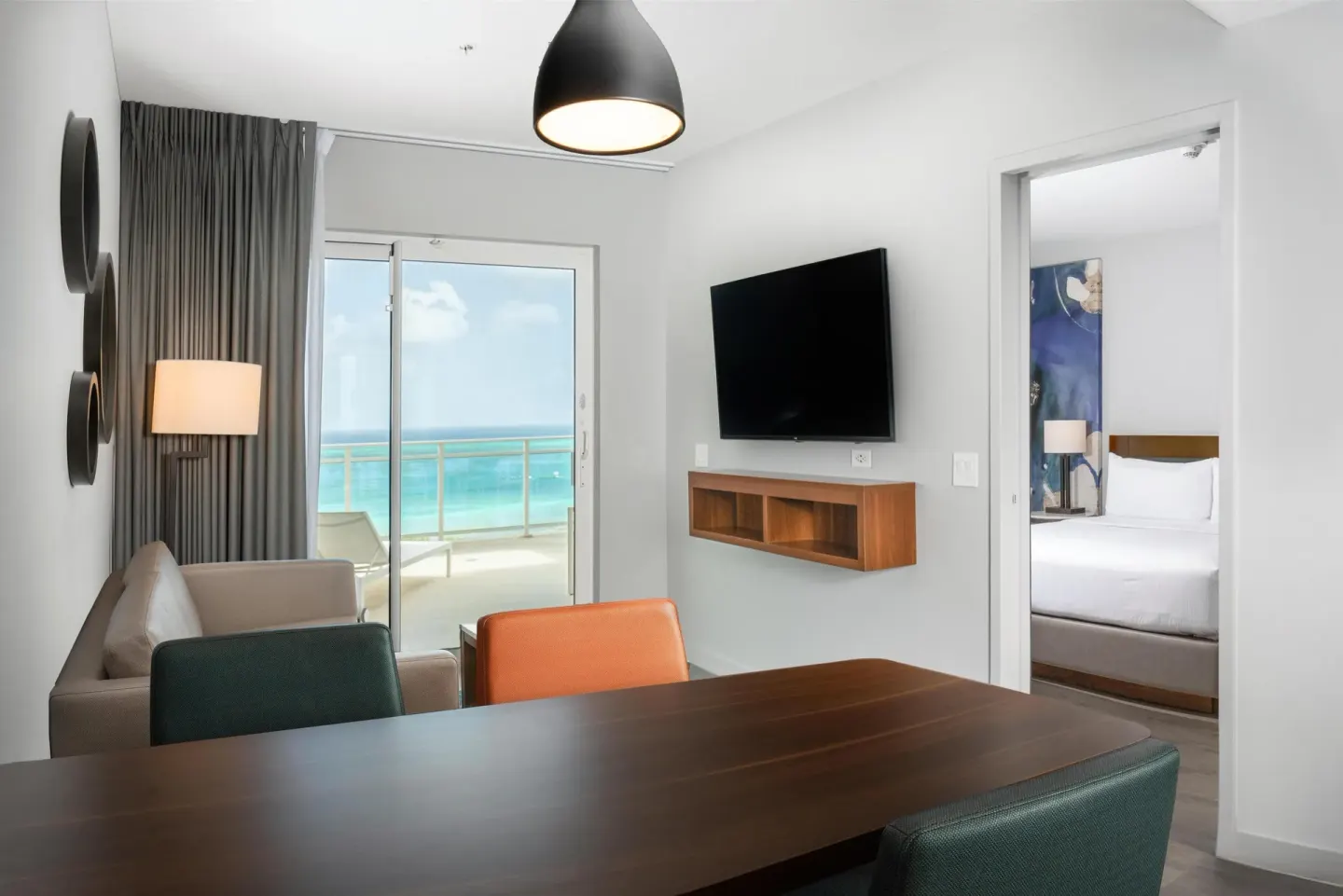 Ocean-view suite living room with balcony and bedroom doorway at Embassy Suites Aruba Beach Resort.