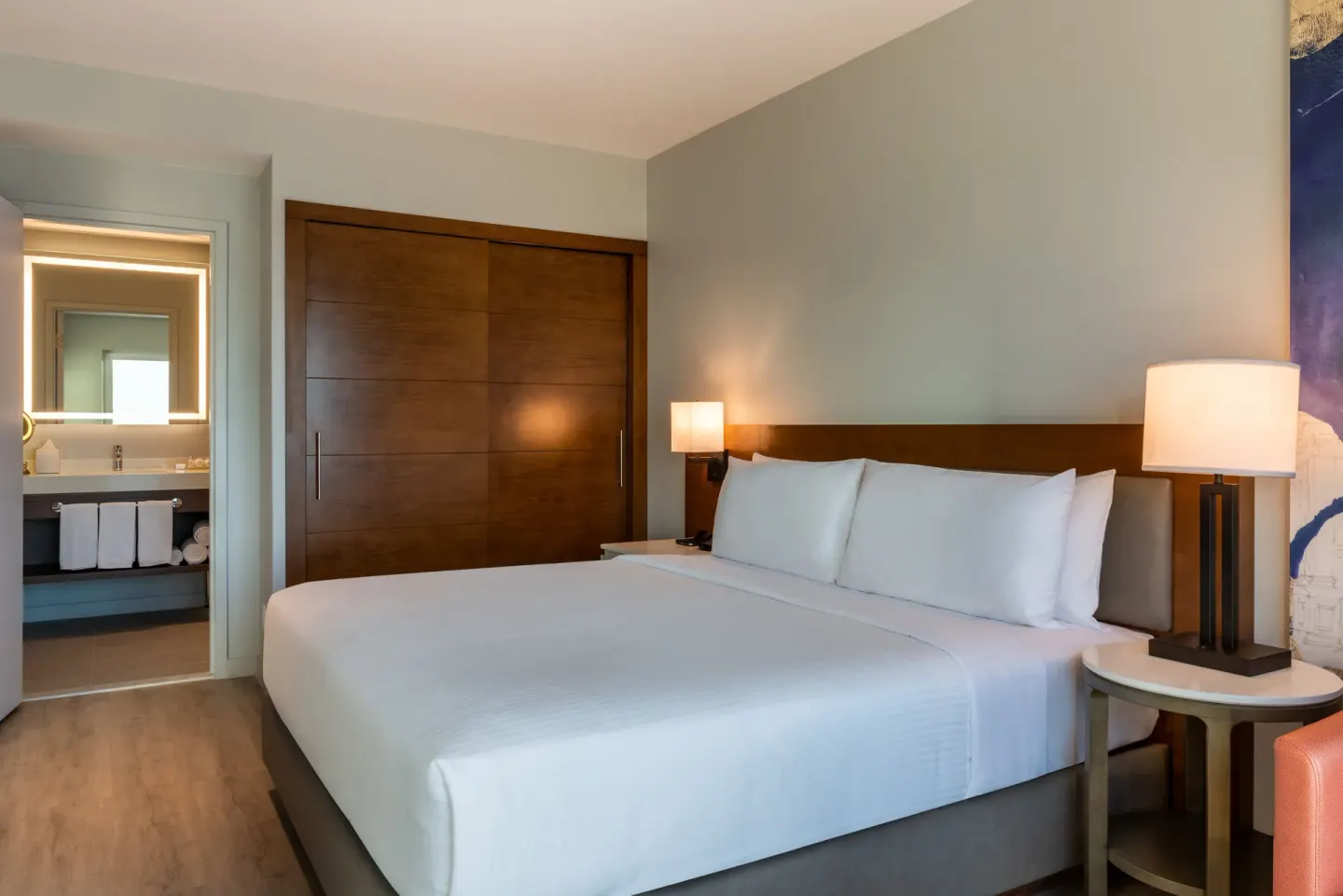 King bedroom with bath entry in a suite at Embassy Suites Aruba Beach Resort.