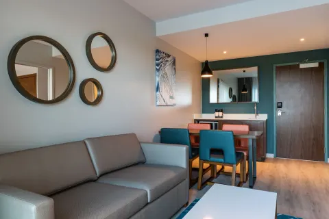 Living area with sofa and dining table in a suite at Embassy Suites Aruba Beach Resort.