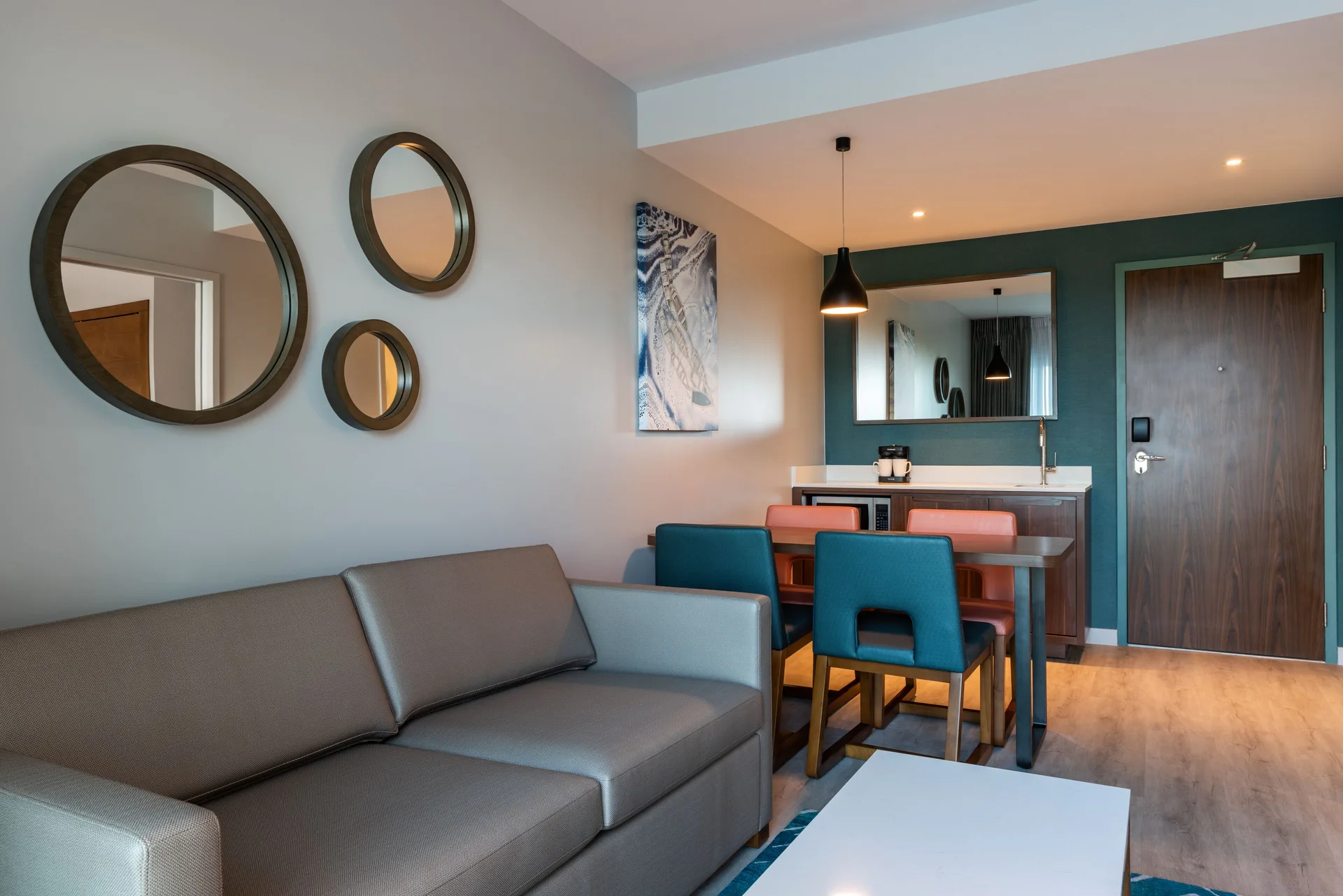 Living area with sofa and dining table in a suite at Embassy Suites Aruba Beach Resort.