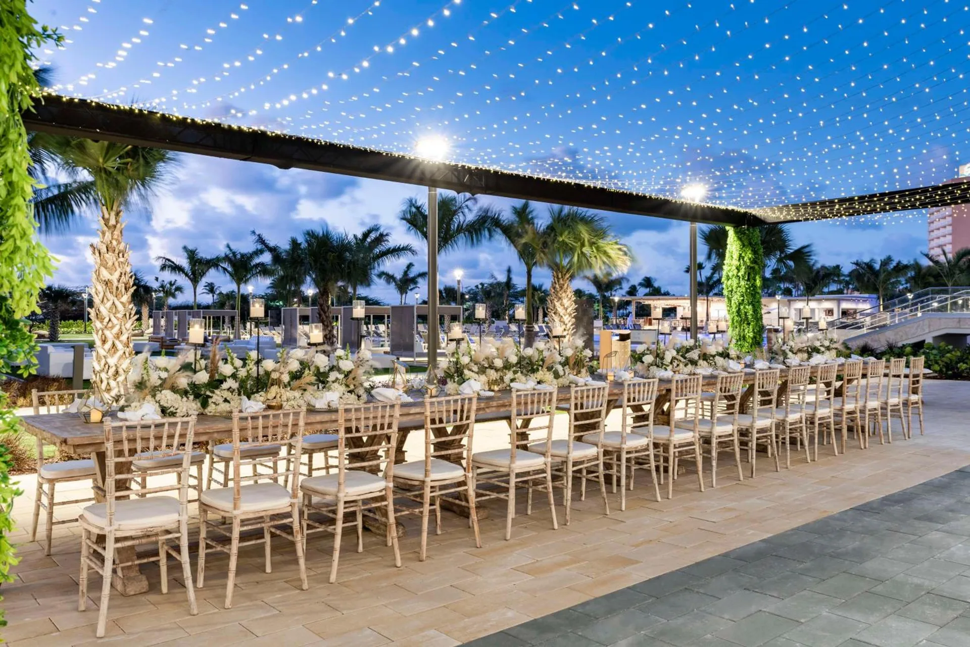 Outdoor event dinner setup under string lights at Embassy Suites Aruba Beach Resort.