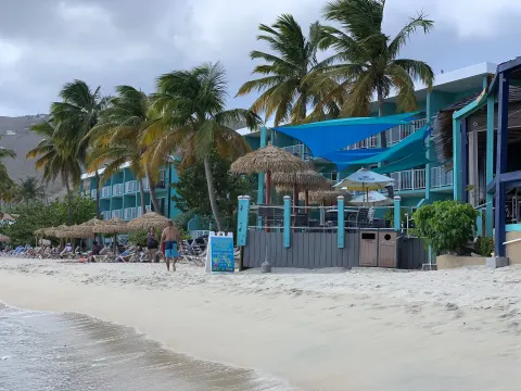Beachfront buildings, palms, and sand seating at Emerald Beach Resort.