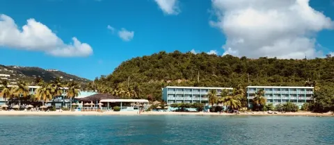 Beachfront resort buildings and sandy shore seen from the water at Emerald Beach Resort.