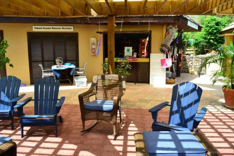 Shaded courtyard seating with blue chairs and shopfronts at Emerald Beach Resort.
