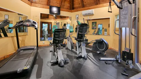 Fitness room with cardio machines and mirrors at Emerald Beach Resort.