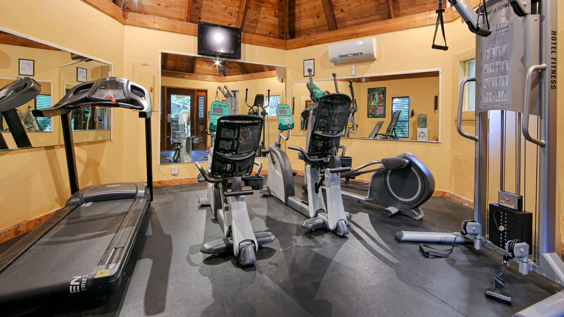 Fitness room with cardio machines and mirrors at Emerald Beach Resort.
