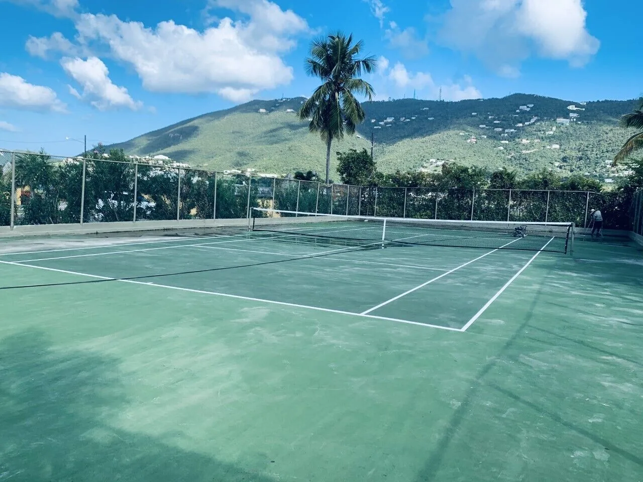Outdoor tennis court with mountain views at Emerald Beach Resort.