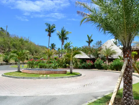 Circular driveway with fountain, palms, and tropical buildings at Emerald Beach Resort.