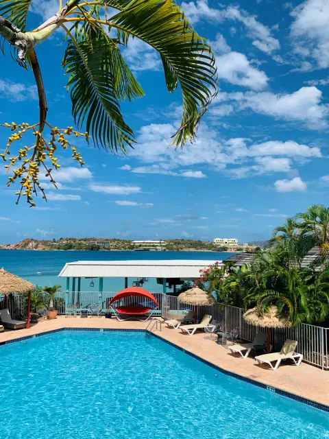 Pool deck overlooking turquoise bay water at Emerald Beach Resort.