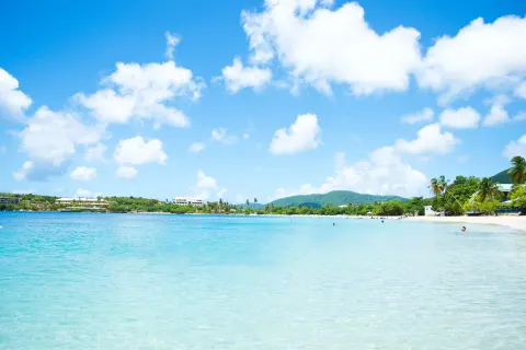 Turquoise bay and sandy shoreline near Emerald Beach Resort under a bright blue sky.
