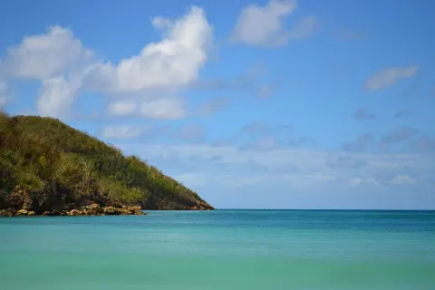 Calm turquoise water and a green headland near Emerald Beach Resort.