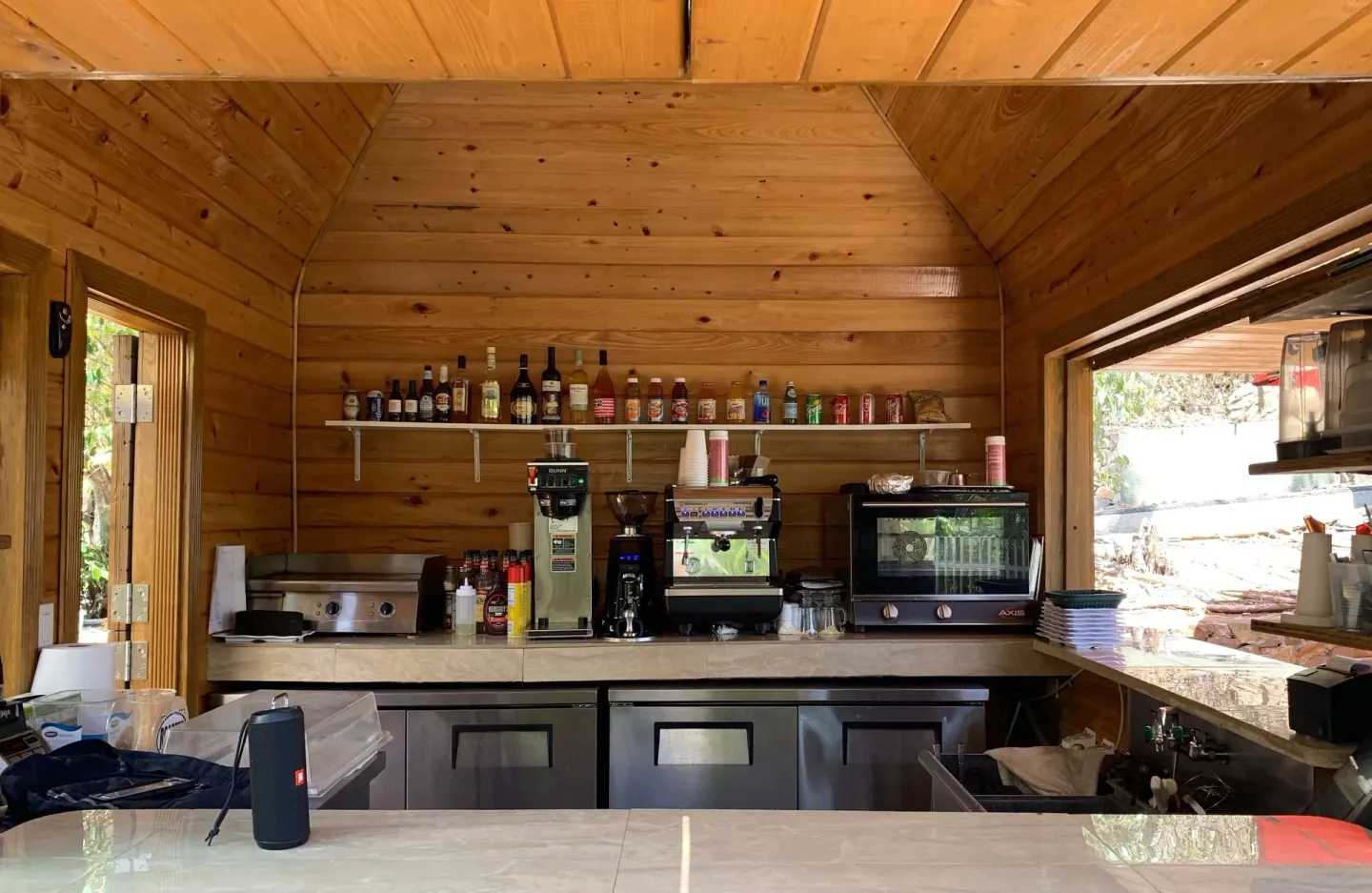 Wood-paneled café counter with coffee equipment and drinks at Emerald Beach Resort.