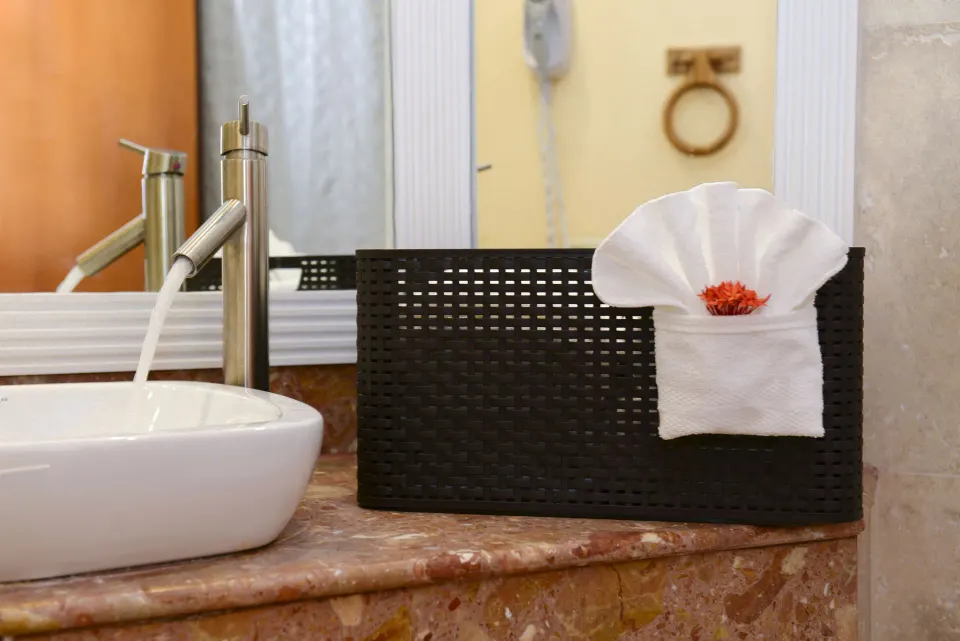 Close-up of bathroom sink and folded towel basket at Emerald Beach Resort.