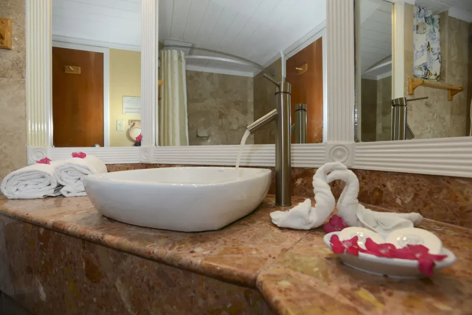 Bathroom vanity with towels, swan fold, and vessel sink at Emerald Beach Resort.